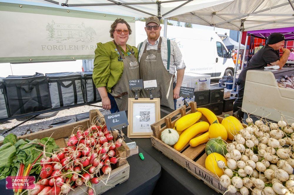 Fresh local vegetables including radishes, squash, and garlic at Moray Events farmers market in Moray, Scotland.