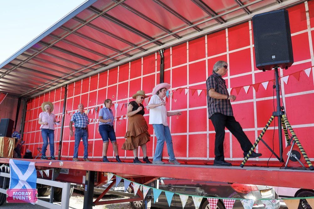 People participating in outdoor event on stage at Moray Events, showcasing community gatherings and celebrations in Moray, Scotland.